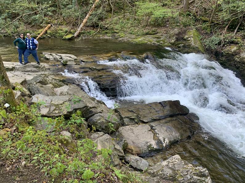 A person standing on rocks near a waterfall

Description automatically generated with low confidence