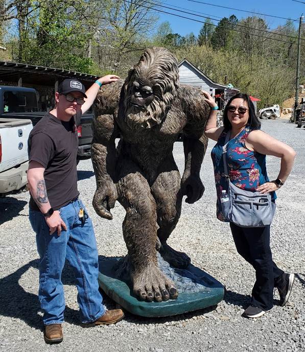 A person and person posing for a picture with a statue of a monster

Description automatically generated with low confidence