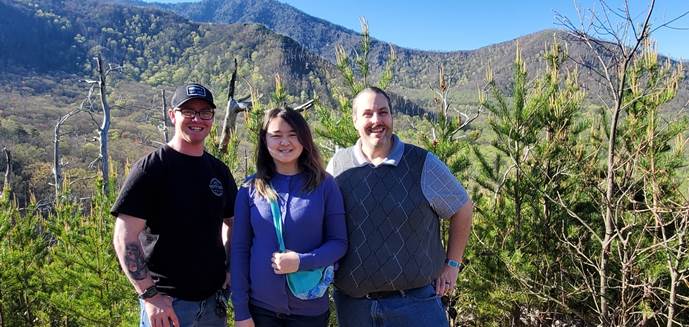 A group of people standing in front of a mountain

Description automatically generated with medium confidence